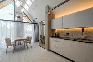 ビャウカにあるRezydencja Słoneczna - SPA & Apartamenty z widokiem - Białka Tatrzańskaのテーブルと椅子のあるキッチンとダイニングルーム