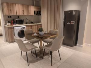 eine Küche mit Tisch, Stühlen und Kühlschrank in der Unterkunft سدارا للأجنحه الفندقيه in Riad