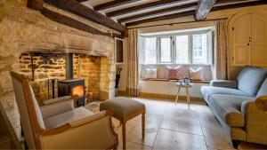 a living room with a couch and a fireplace at Spinner's Cottage in Burford +17 photos