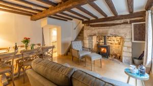 a living room with a couch and a fireplace at Spinner's Cottage in Burford