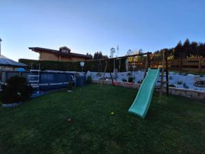 a playground with a green slide in a yard at Ferienwohnung Julia Kröll in Mittersill