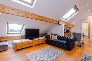 a living room with a couch and a flat screen tv at The Loft Apartments | Cheadle in Cheadle Hulme