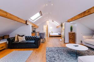 a living room with a black couch and a table at The Loft Apartments | Cheadle in Cheadle Hulme