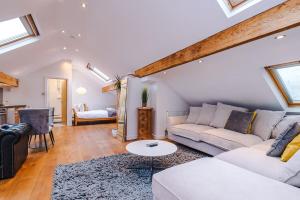 a living room with a couch and a table at The Loft Apartments | Cheadle in Cheadle Hulme +19 photos