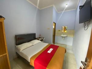 a small room with a bed and a sink at Aqilakost Gadog Puncak Bogor in Bogor