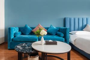 a living room with a blue couch and a table at Livetour Hotel Luogang Wanda Plaza Suyuan Metro Guangzhou in Guangzhou