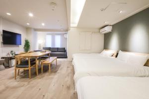 a hotel room with two beds and a dining room at RIVER CENTRAL HIROSHIMA in Hiroshima