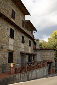 an old stone building with a fence in front of it at Casa San Donato in San Donato in Fronzano +18 photos