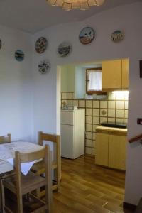 a kitchen with a table and a white refrigerator at Casa San Donato in San Donato in Fronzano