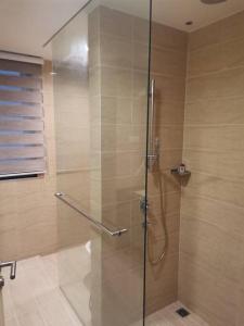 a shower with a glass door in a bathroom at By The Sea Beach Front Sea view Apartment 3 in Batu Ferringhi