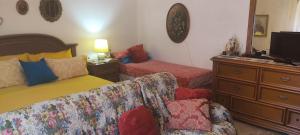 a bedroom with a bed and a couch and a dresser at Amabile Guesthouse in Milis