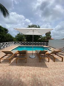 Una sombrilla blanca junto a una piscina. en Pacific Breeze # Luxury villa, en Jan Thiel