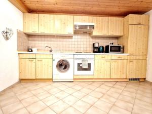 a kitchen with a washing machine and a microwave at Schöne Wohnung mit Garten nahe schweizer Grenze in Küssaberg