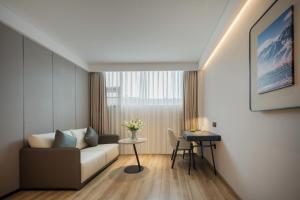 a living room with a couch and a table at Atour Hotel -Du Fu Thatched Cottage in Chengdu
