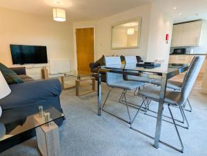a living room with a table and a couch at Parkgate 2 bed, private parking, Rosyth M90 in Rosyth