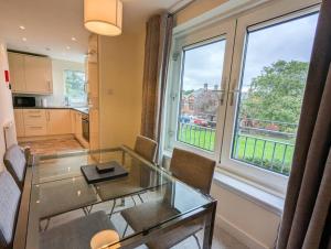 a living room with a glass table and a window at Parkgate 2 bed, private parking, Rosyth M90 in Rosyth