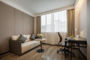 a living room with a couch and a desk at Atour Hotel -Du Fu Thatched Cottage in Chengdu