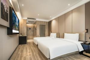a hotel room with two beds and a flat screen tv at Atour Hotel -Du Fu Thatched Cottage in Chengdu +88 photos