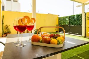 a tray of fruit on a table with two glasses of wine at Sun Terrace Home by Propertize in Quartu SantʼElena