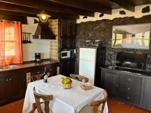 a kitchen with a table and a white refrigerator at Casa Rural La Vega in Agulo