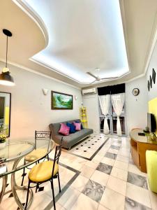 un soggiorno con un divano, un tavolo e delle sedie di De One Homestay Bayu Emas Near Beach a Batu Ferringhi