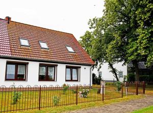 a white house with a fence in front of it at schoene Ferienwohnung mit Terrasse in Ralswiek