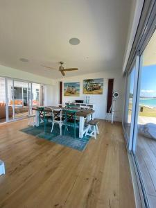 a dining room with a table and chairs and the ocean at Rangi Beachfront -Luxury Beachfront Bach in Karikari Peninsula +15 photos
