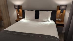 OudenboschAntonius Hoeve Chalets的卧室里有一张铺着白色床单的床和两盏灯