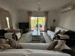 a living room with two couches and a tv at The Santander Villa in Orihuela Costa