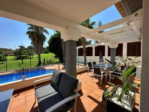 a patio with a table and chairs and a pool at The Santander Villa in Orihuela Costa