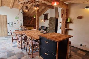 eine Küche und ein Esszimmer mit einem Holztisch und Stühlen in der Unterkunft Le Grenier de Jules et Marguerite in Liézey