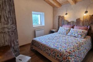 ein Schlafzimmer mit einem Bett mit einem hölzernen Kopfteil in der Unterkunft Le Grenier de Jules et Marguerite in Liézey