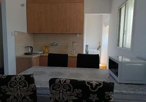 a kitchen with a table with chairs and a counter top at Apartments by the beach 60-6 in Qiryat H̱ayyim +9 photos