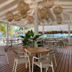 a restaurant with tables and chairs and chandeliers at Relax at Private beach, Pools, Acuatic Park & more in Bayahibe