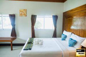 通萨拉First and Frang Hotel - Koh Phangan的一间卧室配有一张带木制床头板和窗户的床。