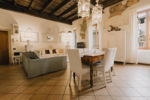 a living room with a table and chairs and a couch at Piazza Erbe Luxury Apartment in Verona