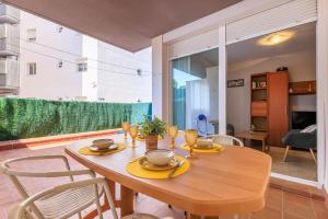 Un comedor con mesa y sillas de madera. en UHC GOLDEN PINEDA APARTMENTS, en La Pineda