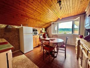 a kitchen with a table and a white refrigerator at Le Nid du Lac in Saint-Point-Lac
