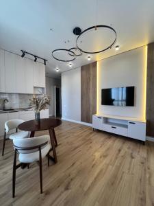 a kitchen and living room with a table and a tv at Bravo Family apartment in Promyshlennyy