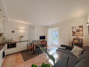 a living room with a couch and a table and a kitchen at Lake House in Nago-Torbole
