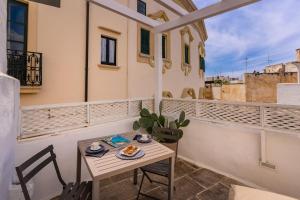 a small table and chairs on the balcony of a building at Al Riparo in Gallipoli