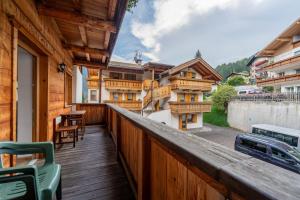 a balcony with a wooden railing with a table and chairs at Cesa Rosy in Campitello di Fassa