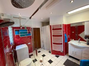 y baño con azulejos rojos, ducha y lavamanos. en Sommerhaus, en Bremervörde 24 fotos más