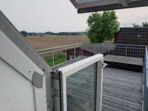 a deck with a view of a field at Finca Franca in Klein Wittensee