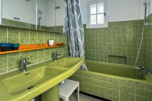 a green bathroom with a sink and a tub at Bug Ar Mor - Vue Exceptionnelle des 7 Îles in Penvénan +82 photos
