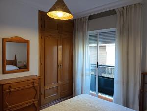 a bedroom with a mirror and a dresser and a window at Casa Delfin in Punta Umbría