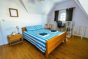 a bedroom with a bed with a blue and white comforter at Bug Ar Mor - Vue Exceptionnelle des 7 Îles in Penvénan