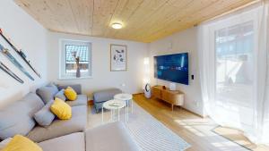 a living room with a couch and a tv at HEIMATEL - Ferienhaus Prinz-Lui in Scheidegg