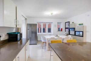 スラウにあるFoxherne 6 Bedroom 3Bath Serviced House 18 with Parking - Sloughのテーブルと椅子のあるキッチンとダイニングルーム