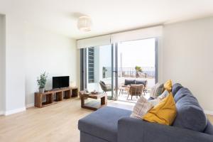 AbadesにあるHome2Book Orballo Sea Views Apt, Terrace&Poolの青いソファとテレビのあるリビングルーム